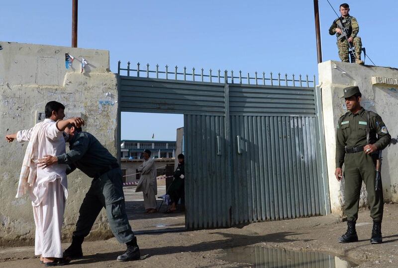 An Afghan policeman searches a voter before he enters a polling station to cast his vote in Kandahar on April 5, 2014. Afghan voters went to the polls to choose a successor to President Hamid Karzai, braving Taliban threats in a landmark election held as US-led forces wind down their long intervention in the country. Banaras Khan / AFP