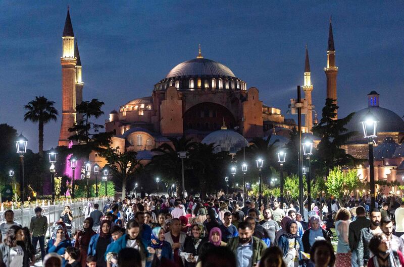 People stroll at the sunset in front of the Blue Mosque square in Istanbul. AFP