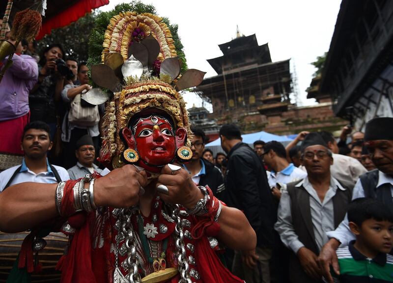 A Nepali traditional masked dancers prepares to perform on the first day of the Indra Jatra festival at Hanuman Dhoka in Kathmandu.  AFP