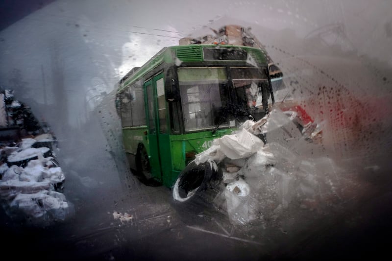 A barricade made of trams, buses and sand bags is seen through the window of car in the northern part of Kyiv. AP