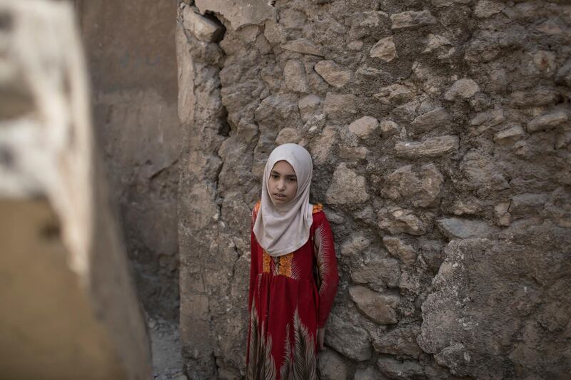 A girl stops in exhaustion while fleeing through an alley, as Iraqi Special Forces continue their advance against Islamic State militants, in the Old City of Mosul, Iraq, Sunday, July 2, 2017. (AP Photo/Felipe Dana)