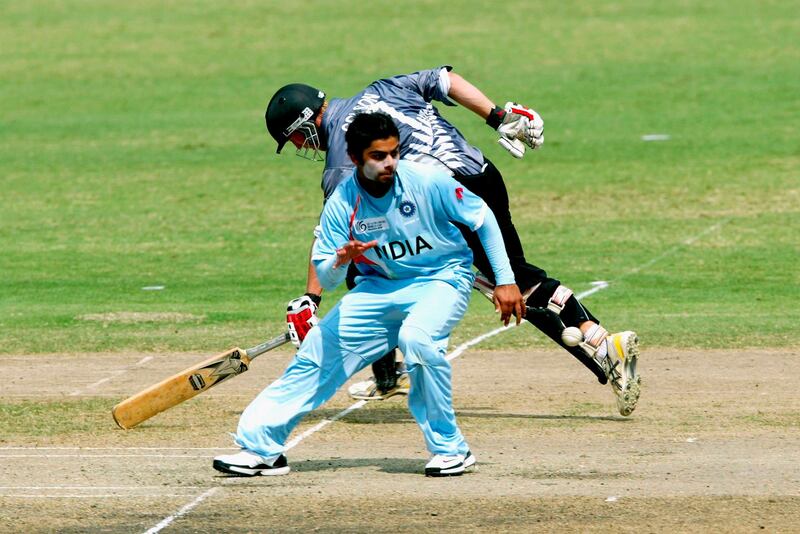 KUALA LUMPUR, MALAYSIA - FEBRUARY 27: Fraser Colson of New Zealand grounds his bat while Virat Kohli of India attempts to gather the ball during the ICC U/19 Cricket World Cup semi final match between India and New Zealand held at the Kinrara Cricket Ground on February 27, 2008 in Kuala Lumpur, Malaysia. (Photo by Stanley Chou/Getty Images)