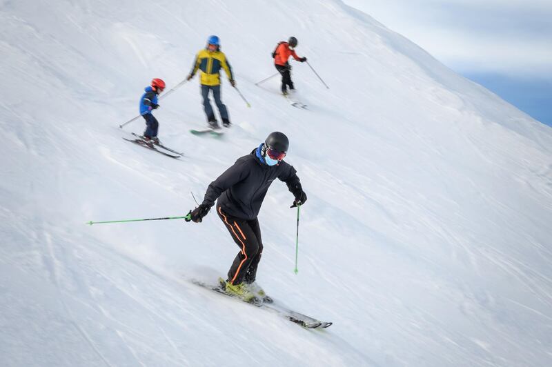 Skiers wearing protective face masks hit the slopes in the Swiss ski resort of Verbier in the Swiss Alps. AFP