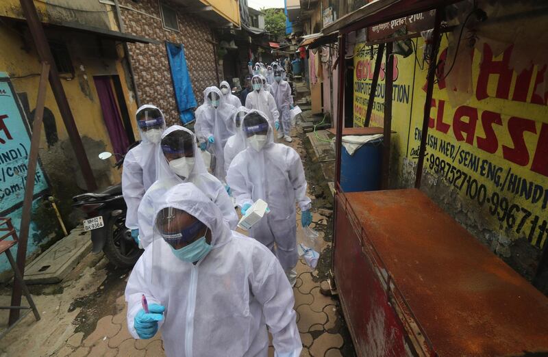 Health workers arrive to run a feaver camp in a slum in Mumbai. AP