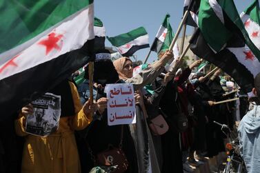 A Syrian woman in Idlib holds a placard reading 'boycott because you are a human being' during a protest against the presidential election. EPA