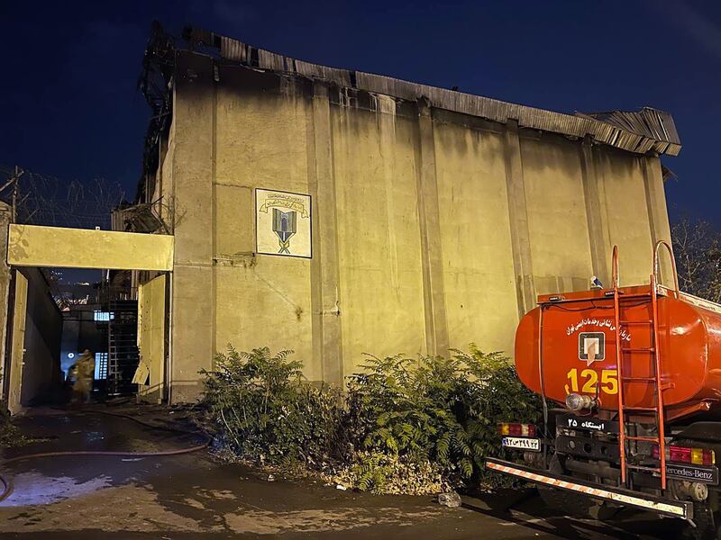 A fire truck stands in front of a charred building after a fire broke out at the prison. EPA