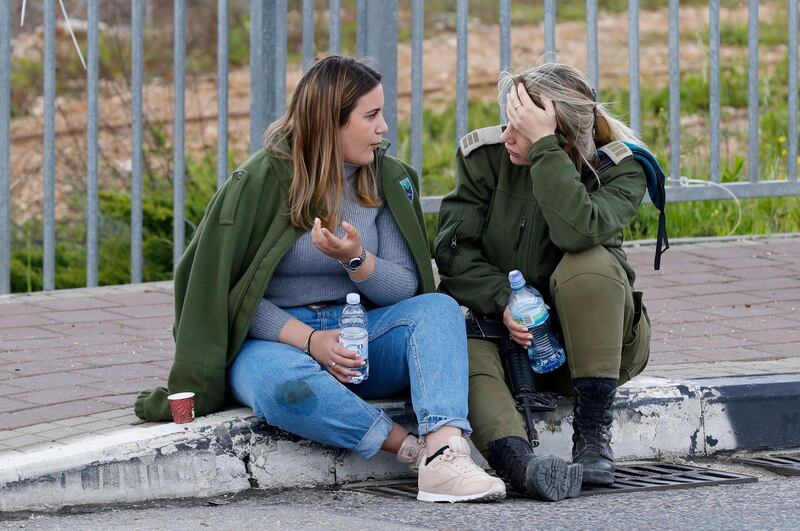 An Israeli soldier speaks to a woman at the site of an attack at the Ariel junction leading to the Israeli settlement of Ariel, in the occupied West Bank. AFP