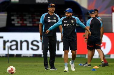 India's Rohit Sharma (center R) warms up as team's head coach Ravi Shastri watches before the start of the ICC men’s Twenty20 World Cup cricket match between India and Namibia at the Dubai International Cricket Stadium in Dubai on November 8, 2021.  (Photo by Aamir QURESHI  /  AFP)