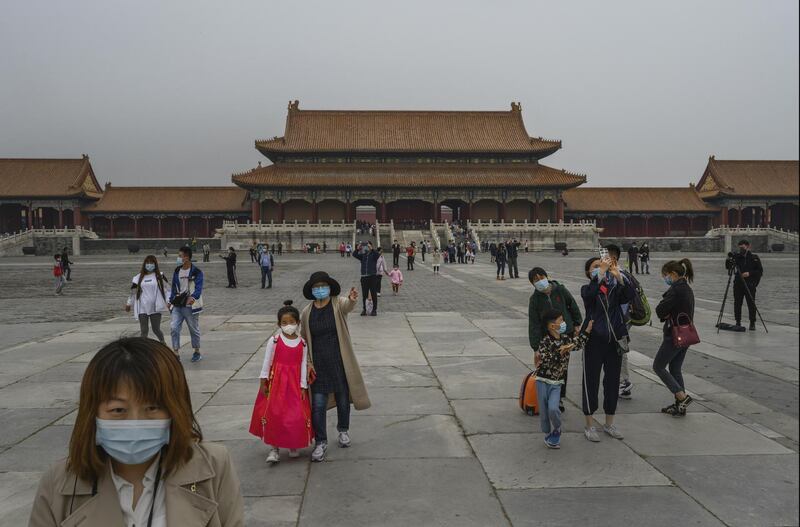 Visitors wear protective masks as they tour the Forbidden City, which recently re-opened to limited visitors, in Beijing, China. Getty Images