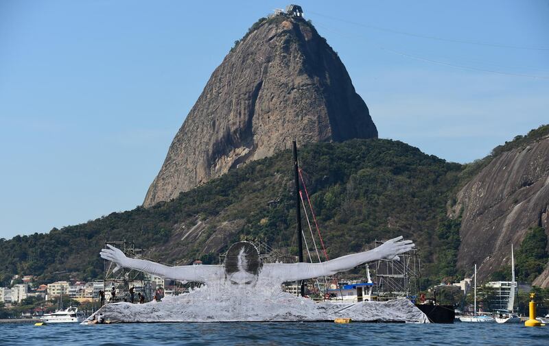 French artist JR's giant print of an athlete swimming is seen at Guanabara Bay in Rio de Janeiro, Brazil on August 6, 2016. (Photo by TASSO MARCELO / AFP)