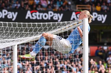 WOLVERHAMPTON, ENGLAND - SEPTEMBER 17: Erling Haaland of Manchester City swings from the crossbar during the Premier League match between Wolverhampton Wanderers and Manchester City at Molineux on September 17, 2022 in Wolverhampton, England. (Photo by Laurence Griffiths / Getty Images)