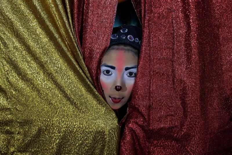 Joshep Balta, a clown named "Cachupito," peers through the tent curtain to see how many people are waiting for the show, put on by the International Circus, on the outskirts of Lima, Peru. Martin Mejia/AP Photo