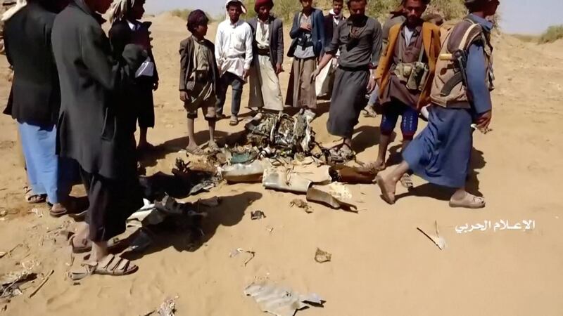 People inspect purported plane wreckage in Yemen's Jawf provoince. Houthi Media Centre via Reuters