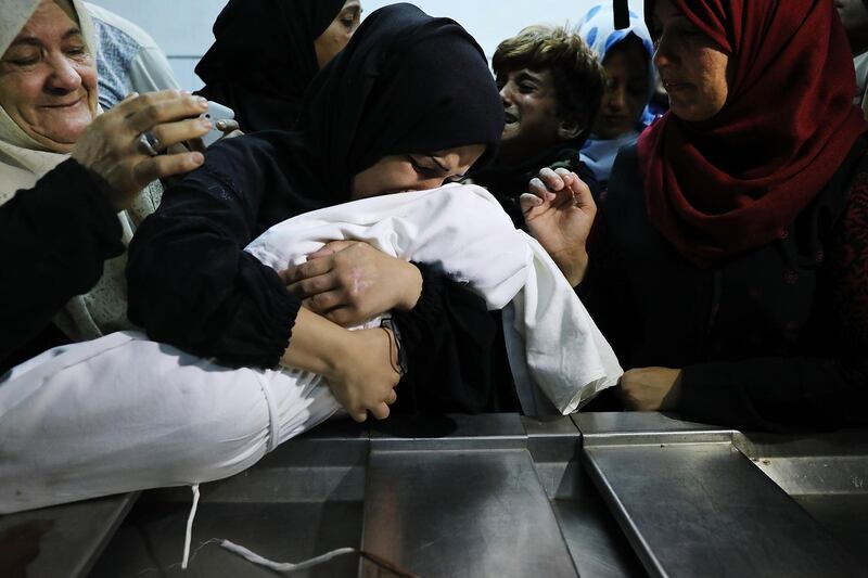 GAZA CITY, GAZA - MAY 15:  (EDITORS NOTE: Image depicts death.) The mother of eight-month-old Leila Anwar Ghandoor, who died in the hospital on Tuesday morning from tear gas inhalation, hugs her daughter a last time as she is prepared for burial on May 15, 2018 in Gaza City, Gaza. Anwar was with a relative during the violence at the Gaza-Israel border yesterday when tear gas canisters were fired at crowds. Israeli soldiers killed over 50 Palestinians and wounded over a thousand as demonstrations on the Gaza-Israel border coincided with the controversial opening of the U.S. Embassy in Jerusalem. This marks the deadliest day of violence in Gaza since 2014. Gaza's Hamas rulers have vowed that the marches will continue until the decade-old Israeli blockade of the territory is lifted.  (Photo by Spencer Platt/Getty Images)