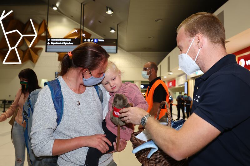 A West Australian Tourism representative offers a young passenger a toy Quokka on arrival at Perth International Airport Terminal. Photo by Paul Kane / Getty Images