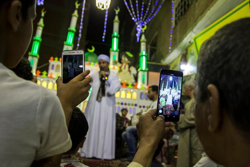 People take videos for a man singing Islamic songs during celebrations two days ahead of the holy month of Ramadan at al-Baragel, Cairo, Egypt. EPA