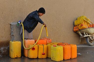 A boy fills a container with tap water in Kandahar on December 13, 2021.  (Photo by Javed TANVEER  /  AFP)