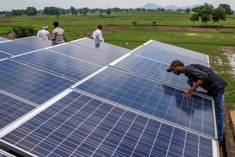 An employee inspects solar panels, part of a solar power microgrid, in the village of Dharnai in Jehanabad, Bihar, India, on Thursday, July 9, 2015. While Prime Minister Narendra Modi's ambition has led billionaires such as Foxconn Technology Group's Terry Gou to pledge investment, the question remains whether the 750 million Indians living on less than $2 per day can afford or will embrace green energy. Photographer: Prashanth Vishwanathan/Bloomberg