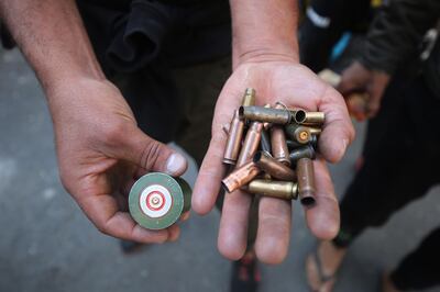 Iraqi anti-government protesters display spent bullet casings during clashes with security forces in al-Rasheed street near al-Ahrar bridge on November 22, 2019. Three anti-government protesters were killed in Iraq's capital, a medical source said, in clashes between defiant demonstrators and security forces trying to keep them back from state offices.  More than 340 people have died and thousands have been wounded since rallies against widespread graft and unemployment erupted in Baghdad and the mostly-Shiite south last month.
 / AFP / AHMAD AL-RUBAYE
