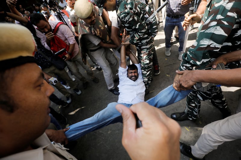 Police detain a supporter of India's main opposition Congress party during a protest after its leader Rahul Gandhi was disqualified from parliament, in New Delhi. Reuters