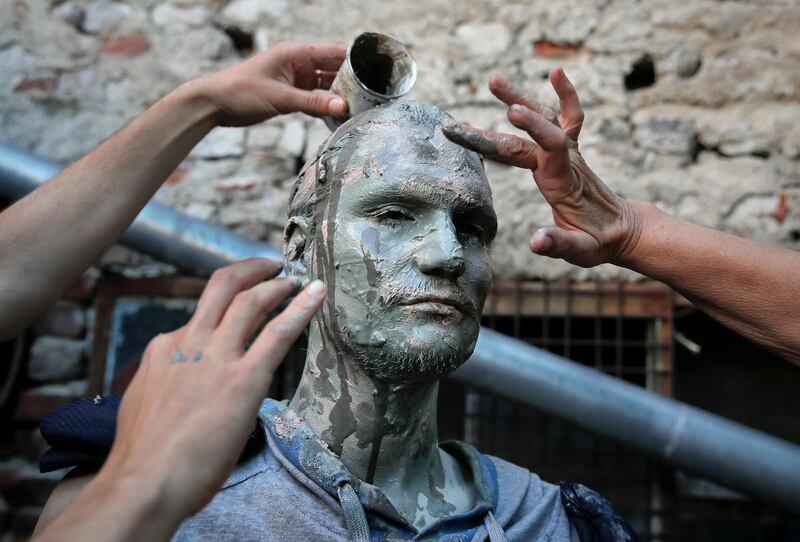 An artist of Romania's Masca theatre has make-up applied to his face before performing at the Living Statues International Festival, in Bucharest, Romania. Vadim Ghirda / AP Photo