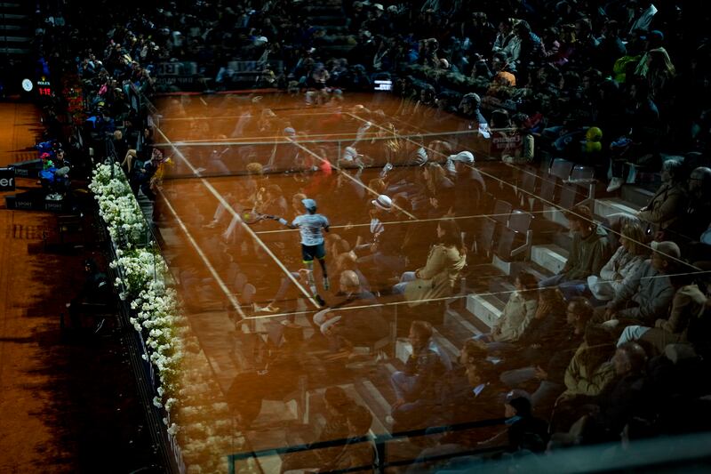 Borna Coric is reflected in a glass barrier as he returns the ball to Stefanos Tsitsipas in an Italian Open quarter-final in Rome. AP