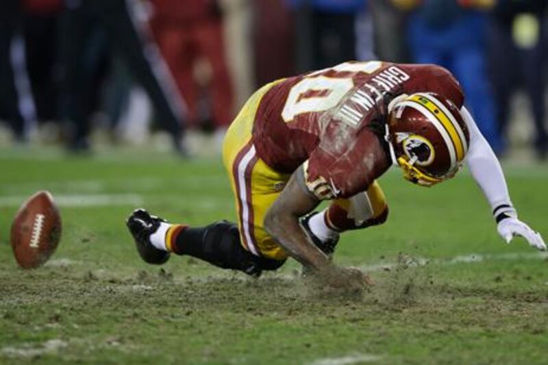 Washington Redskins quarterback Robert Griffin III falls after twisting his knee against Seattle.