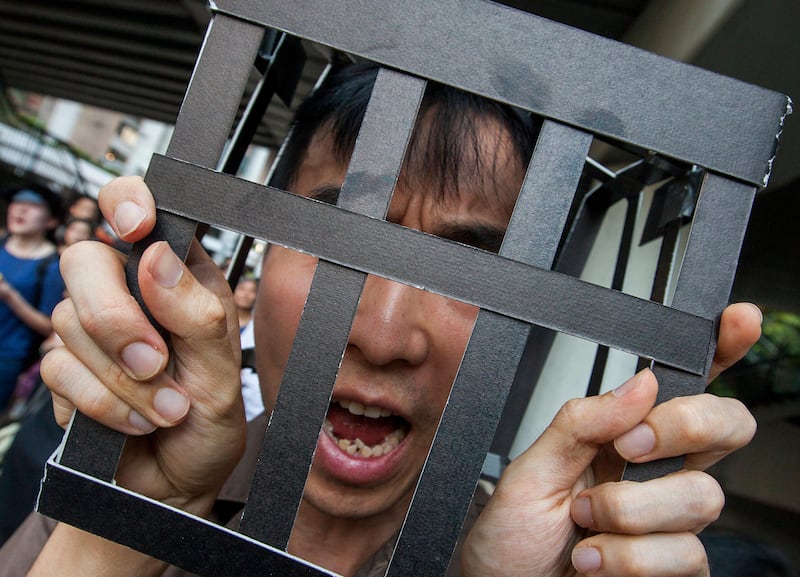 A protester wears a prison uniform and a 'cage' on his head as a statement in support of imprisoned student political activists Joshua Wong, Nathan Law and Alex Chow in Hong Kong. On August 17, the Court of Appeal sentenced Joshua Wong, Alex Chow Yong-kang and Nathan Law Kwun-chung to six, seven and eight months in jail respectively for unlawful assembly on the first day of the Occupy Central Umbrella Movement when they stormed the Civic Square outside the Hong Kong government headquarters on September 2014.  Alex Hofford / EPA