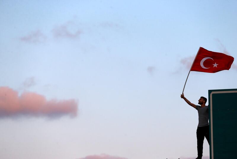 FILE PHOTO: A man waves a Turkey's national flag as he attends a ceremony marking the first anniversary of the attempted coup at the Bosphorus Bridge in Istanbul, Turkey July 15, 2017. REUTERS/Osman Orsal/File Photo