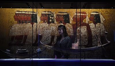 epa07964628 A visitor looks at a painted wooden model solar boat with throne and steering paddles (R) during a press preview for the exhibition 'Tutankhamun: Treasures of the Golden Pharaoh' at the Saatchi Gallery in Chelsea in London, Britain, 01 November 2019.  EPA/FACUNDO ARRIZABALAGA