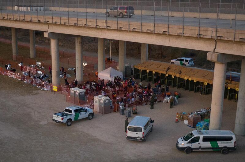 Asylum seeking migrant families with children from Central America take refuge in a makeshift U.S. Customs and Border Protection processing center under the Anzalduas International Bridge after crossing the Rio Grande river into the United States from Mexico in Granjeno, Texas, U.S., March 6, 2021. Picture taken on March 6, 2021.  REUTERS/Adrees Latif