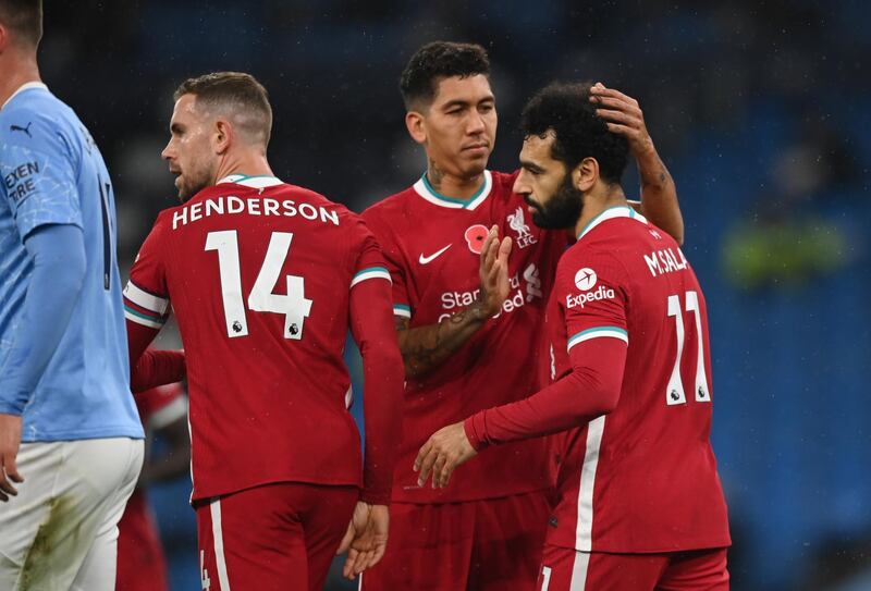 MANCHESTER, ENGLAND - NOVEMBER 08: Mohamed Salah of Liverpool celebrates with teammates Roberto Firmino and Jordan Henderson after scoring his team's first goal during the Premier League match between Manchester City and Liverpool at Etihad Stadium on November 08, 2020 in Manchester, England. Sporting stadiums around the UK remain under strict restrictions due to the Coronavirus Pandemic as Government social distancing laws prohibit fans inside venues resulting in games being played behind closed doors. (Photo by Shaun Botterill/Getty Images)