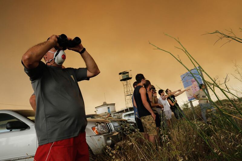 Residents gather to observe a forest fire raging near Maials. AFP