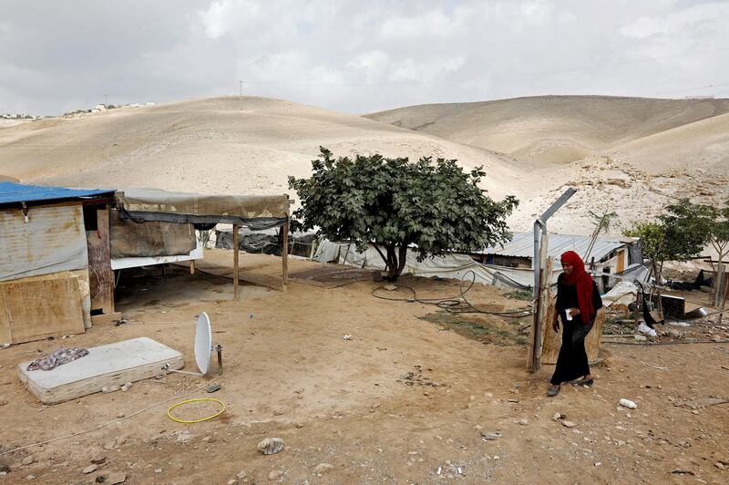 A Palestinian woman walks in the Palestinian Bedouin village of Khan al-Ahmar, east of Jerusalem, in the occupied West Bank, on October 21, 2018. - Israeli Prime Minister Benjamin Netanyahu has frozen plans to demolish a strategically located Bedouin village in the occupied West Bank that has drawn the world's attention, his office said on October 21. "The intention is to give a chance to the negotiations and the offers we received from different bodies, including in recent days," a statement from Netanyahu's office said about Khan al-Ahmar. (Photo by MENAHEM KAHANA / AFP)