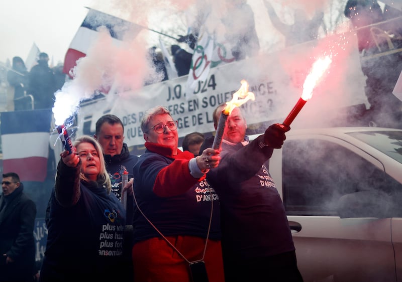 French police union members carry flares during a demonstration calling for better pay and working conditions during the Olympics. EPA