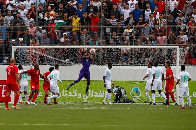 Saudi's goalkeeper Mohammed Alowais (C) saves the ball during the World Cup 2022 Asian qualifying match between Palestine and Saudi Arabia in the town of al-Ram in the Israeli occupied West Bank. The game would mark a change in policy for Saudi Arabia, which has previously played matches against Palestine in third countries. Arab clubs and national teams have historically refused to play in the West Bank, where the Palestinian national team plays, as it required them to apply for Israeli entry permits. AFP