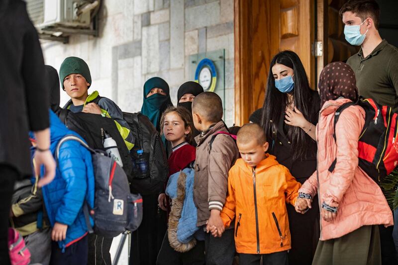 Holding hands, the orphaned children of suspected ISIS fighters are given into the care of a Russian delegation by Syrian Kurdish officials in Qamishli, north-east Syria. AFP