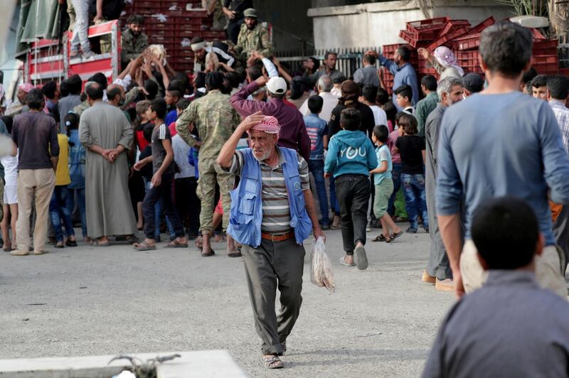 A man holds stacks of bread that was provided by Turkey-backed Syrian rebel fighters in the border town of Tal Abyad, Syria. REUTERS