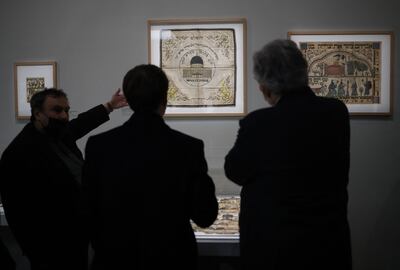 French President Emmanuel Macron, back, and French historian Benjamin Stora, left, visit the exhibition. AFP