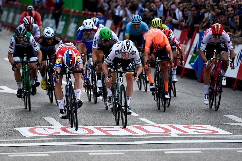 Team Deceuninck's Dutch rider  Fabio Jakobsen, centre,  crosses the finish line and wins the final stage of the Vuelta a Espana. AFP