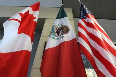 (FILES) In this file photo taken on September 24, 2017 the Mexican, US and the Canadian flags sit in the lobby where the third round of the NAFTA renegotiations are taking place in Ottawa, Ontario.  Canadian and US negotiators reached a deal late on September 30, 2018 on reforming the North American Free Trade Agreement (NAFTA), Canadian media reported. / AFP / Lars Hagberg
