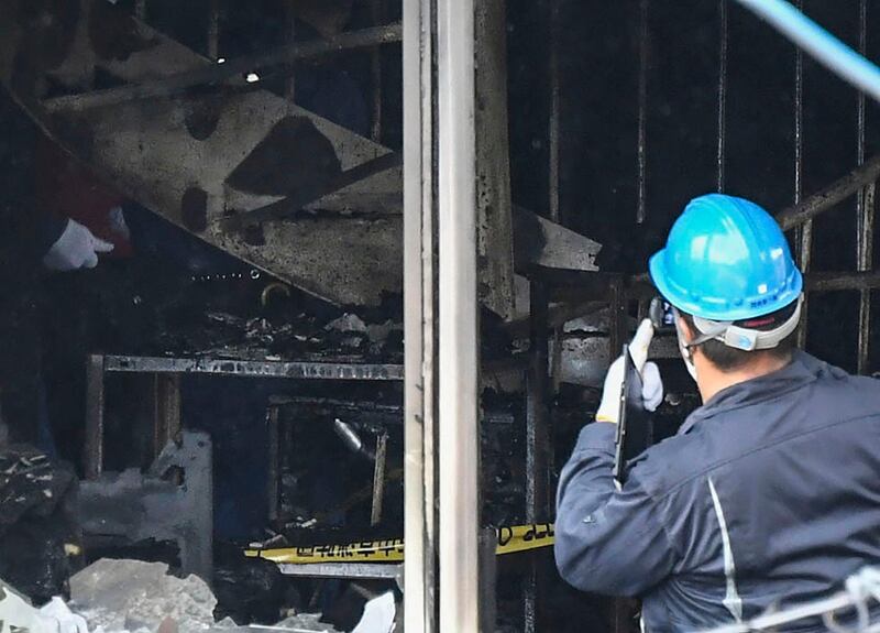 Investigators work inside the building. Kyodo News via AP