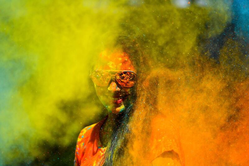 A reveller smeared in colour powder celebrates the Holi, the spring festival of colours, in Mumbai on March 10, 2020. AFP