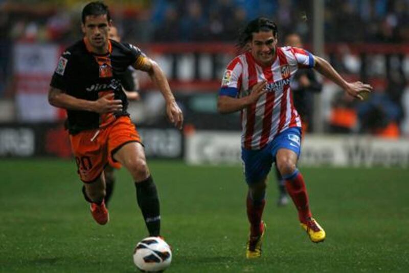 Valencia's Roberto Costa races Radamel Falcao of Atletico Madrid to the ball.