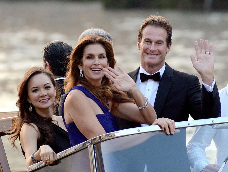 Cindy Crawford and Rande Gerber wave from a boat as they go to George Clooney’s wedding with Amal in Venice. AP