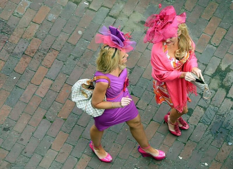 Two women with hats walk to their seats before the start of the 140th Longines Kentucky Oaks at Churchill Downs on May 2, 2014 in Louisville, Kentucky. Jamie Squire / Getty Images / AFP