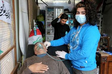 An Iraqi medical aid volunteer treats an anti-government protester at a makeshift hospital at Baghdad's Al Khillani square off the Sinak bridge which links the Iraqi capital's Green Zone with the rest of the city on January 29, 2020. AFP