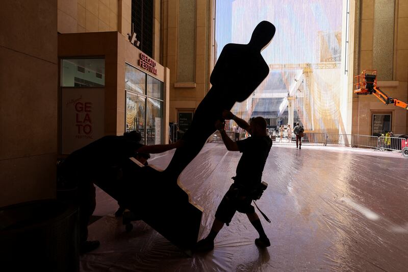 Workers place Oscar statues along the red carpet as preparations for the Academy Awards continue in Los Angeles. Reuters