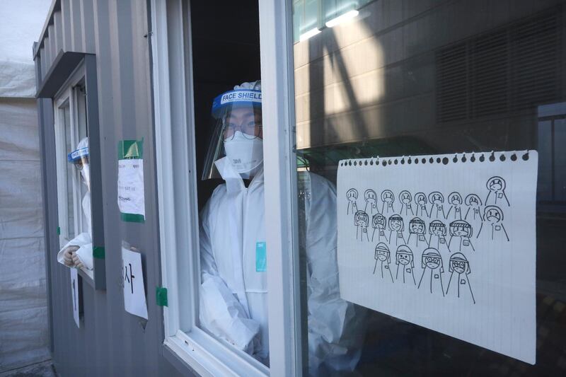 Medical workers in a booth wait for people to come for tests at a coronavirus testing site in Seoul. AP Photo