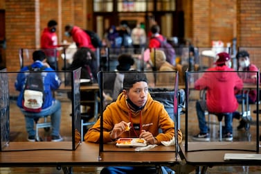 Pupils eat in a cafeteria separated from classmates by plastic dividers at a high school in Kansas City, Kansas. AP